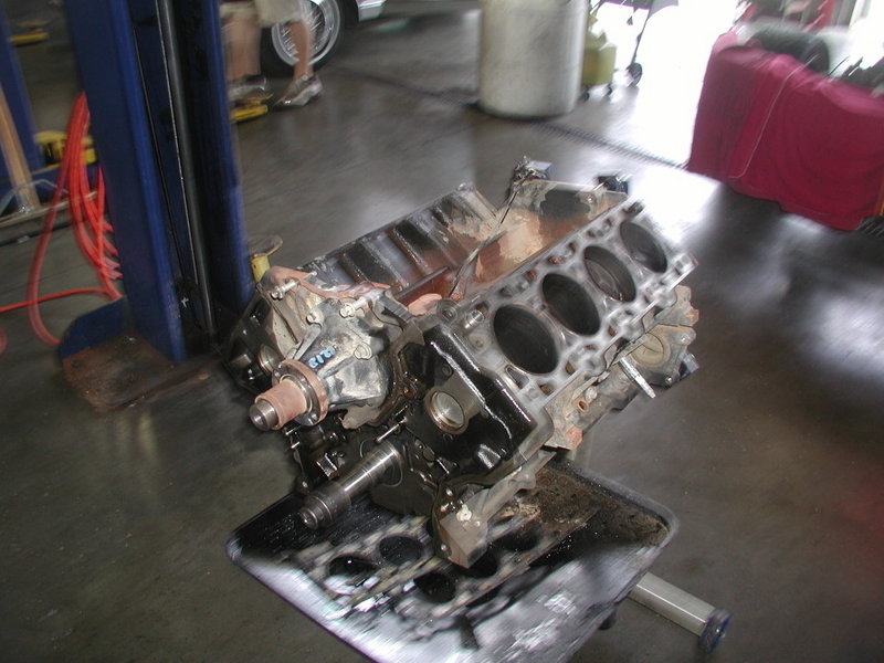 Photo of a bare V8 engine block on a stand in a shop