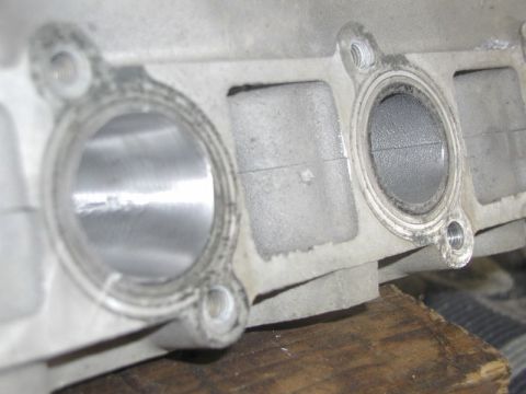 2007 Ford Mustang - Close-up photograph of cylinder head intake port openings and bolt holes, a physical part not a document.