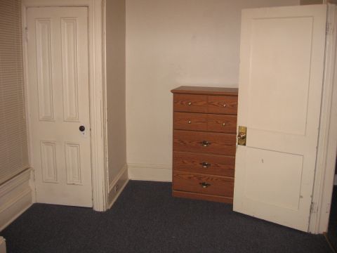 1984 Ford Bronco - A bedroom scene with two doors and a wooden dresser.