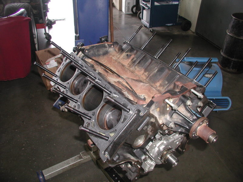 Engine block with cylinder heads removed, mounted on an engine stand in a workshop