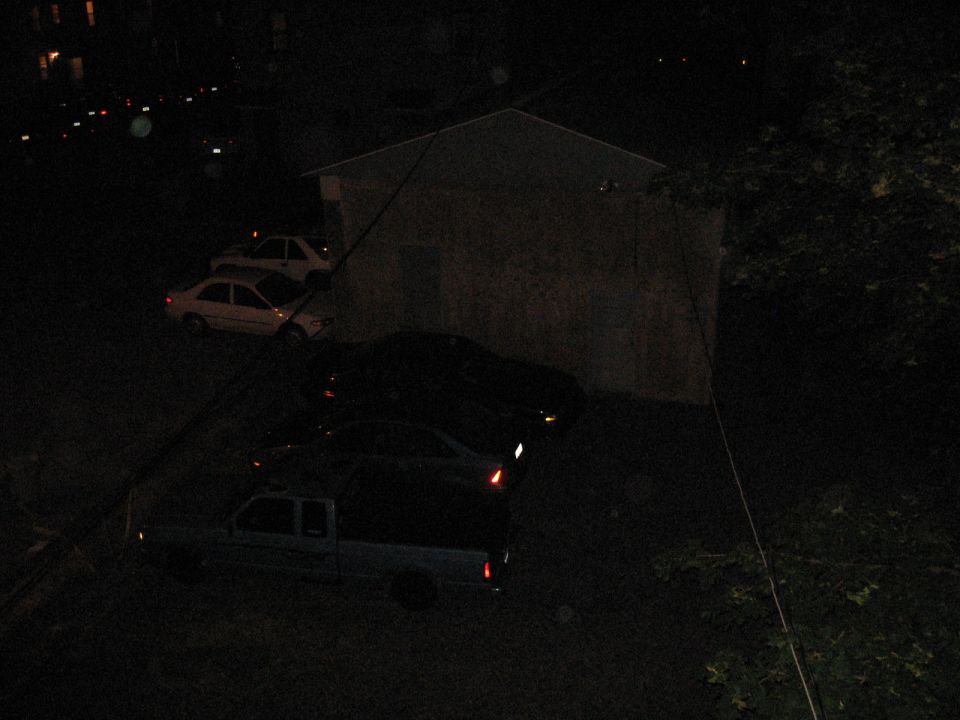 Pickup truck and sedans parked at night