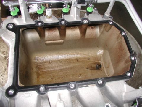 2007 Ford Mustang - Close-up view of an engine intake manifold, showing fuel injectors and a new gasket.