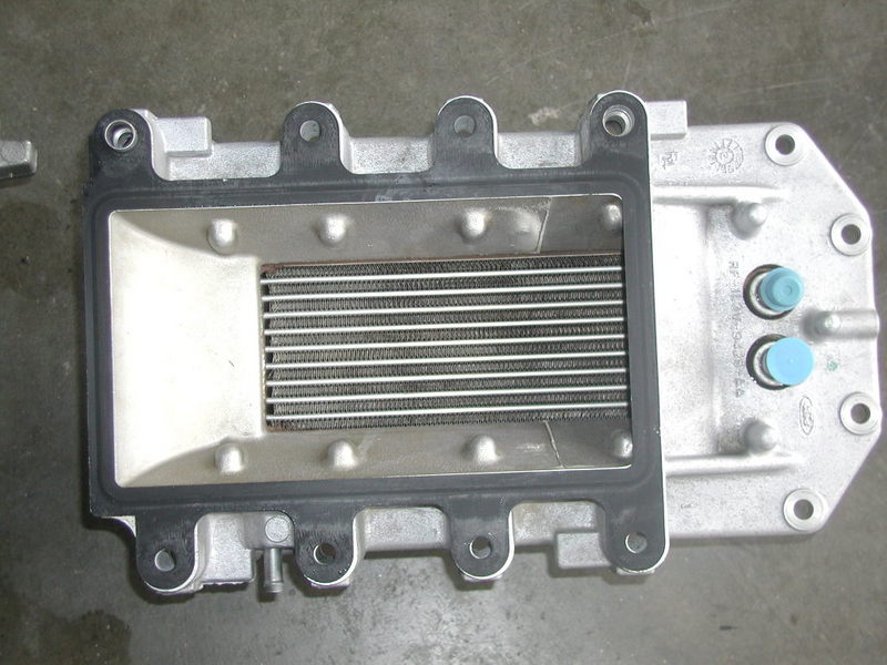 Ford supercharger intercooler assembly with gasket and mounting holes. Ford logo visible