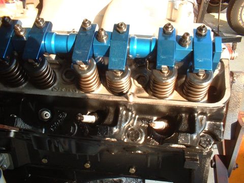 1957 Ford Custom Sedan - Engine block with spark plugs and blue aluminum valve train components.