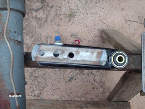 1990 Ford F-150 - Close-up of a vehicle suspension part, possibly a control arm, with a blue cap and bolt visible.