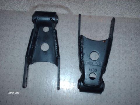 1990 Ford F-150 - Two black metal leaf spring shackles are shown, one with a visible part number.