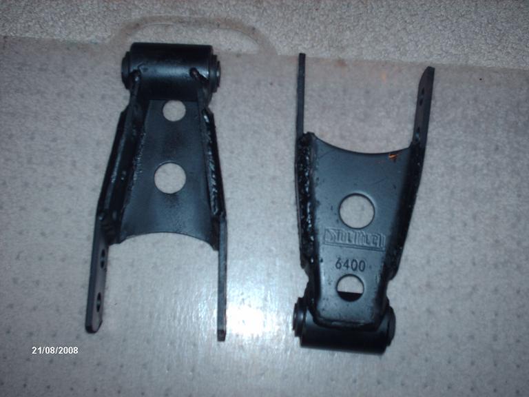 Two black metal leaf spring shackles, one with part number 6400 visible