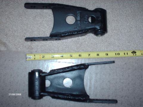1990 Ford F-150 - Two black metal suspension parts are shown with a ruler for scale.