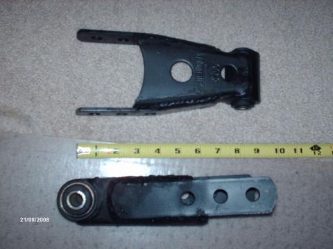 1990 Ford F-150 - Two automotive suspension parts are shown with a measuring tape for scale.