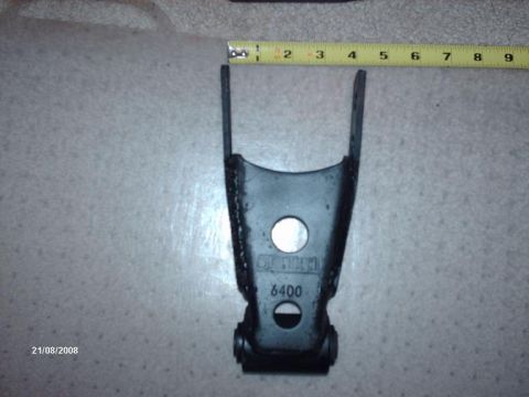 1990 Ford F-150 - A black metal automotive suspension part is shown with a tape measure for scale, scale, and "6400" stamped on its surface.