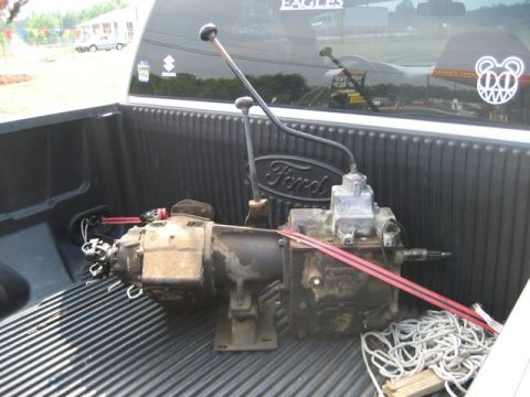 1995 Ford Bronco - Ford NP435 transmission and NP205 transfer case assembly with shifters, secured with red straps in a truck bed.