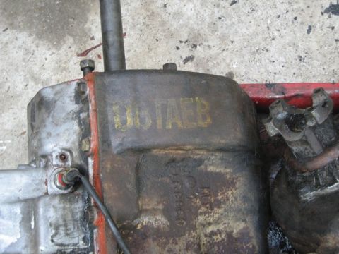 1995 Ford Bronco - Close-up of a weathered engine component with visible markings and a drive shaft connection.