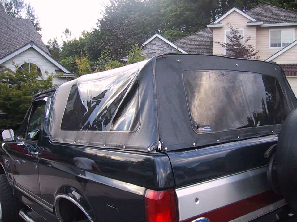 Black 1989 Ford Bronco with a soft top, seen from the side