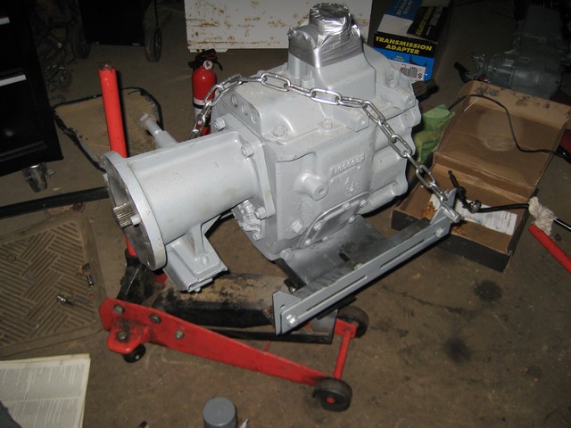 Gray transmission on a red and black transmission jack with a chain.
