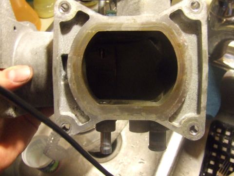 2003 Ford Crown Victoria - Close-up view of the intake manifold opening of a 2003 Ford Crown Victoria. The metal casting shows some wear and residue around the openin…