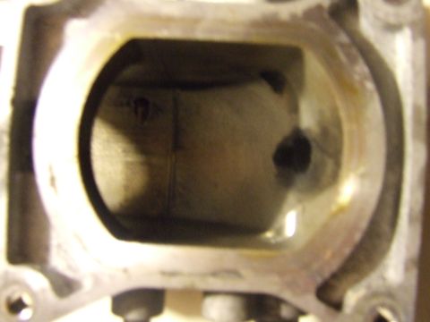 2003 Ford Crown Victoria - This is a close-up, interior view of a metal engine component, likely a cylinder head or intake manifold, showing wear and some dark residu…