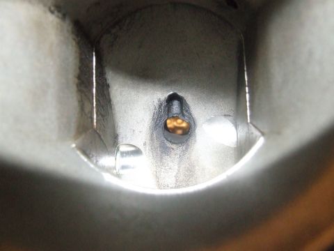 2003 Ford Crown Victoria - Close-up view inside a metal component, possibly an engine part, showing a small opening with a golden-brown interior. The metallic surface…