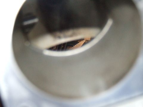 2003 Ford Crown Victoria - A close-up, blurry view looking into a cylindrical opening, revealing a serrated metal edge and some dark, possibly metallic, components wi…