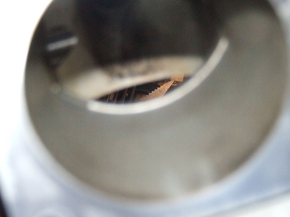 Close-up of a serrated metal edge inside a cylindrical opening.