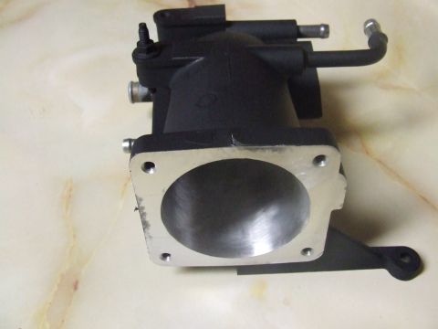 2003 Ford Crown Victoria - A black throttle body with a silver intake opening is shown on a marble surface. The throttle body has two small metal tubes protruding fro…