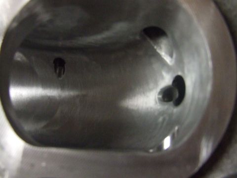 2003 Ford Crown Victoria - Close-up view inside a metal cylinder with two small holes visible. The surface appears machined and has a metallic sheen.