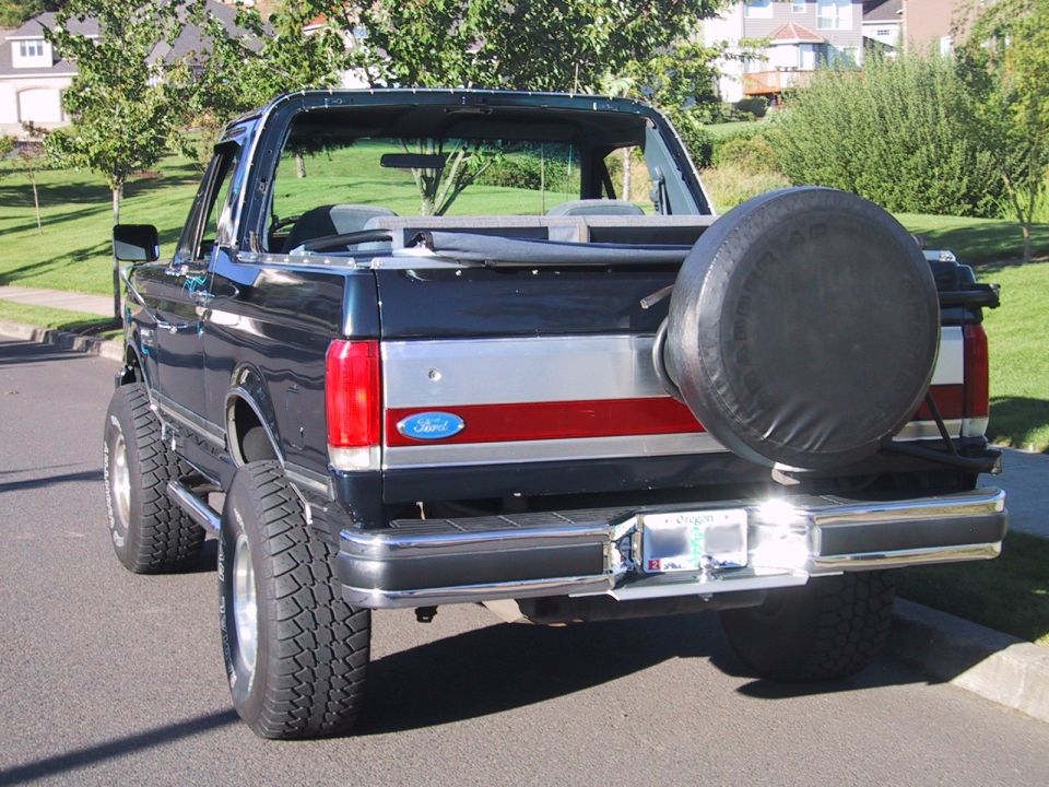 Dark blue topless Ford Bronco from the rear with swing-out spare tire carrier