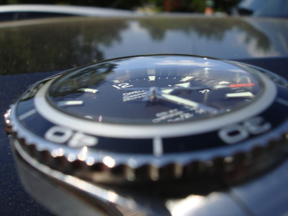 Close-up of an Omega Seamaster watch on a reflective surface.
