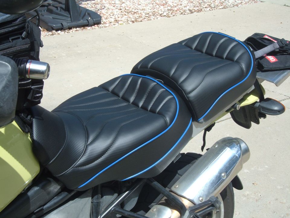 Black motorcycle seat with blue piping and textured pattern