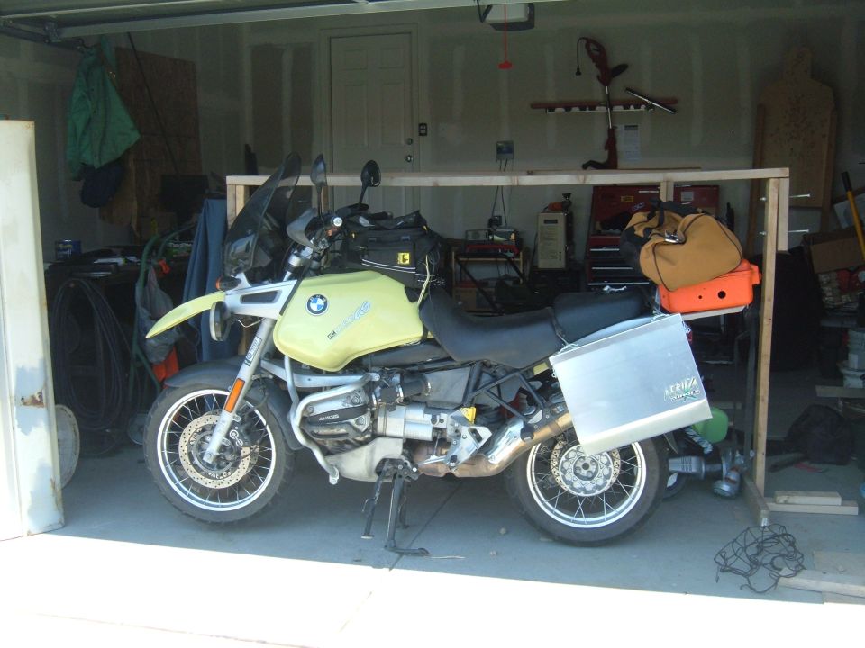 Yellow 1998 BMW R1100GS ABS motorcycle with side case and duffel bag in garage.