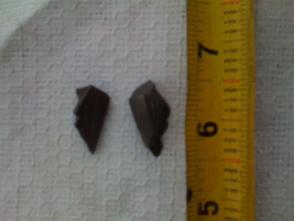 Two dark fragments next to a yellow measuring tape.