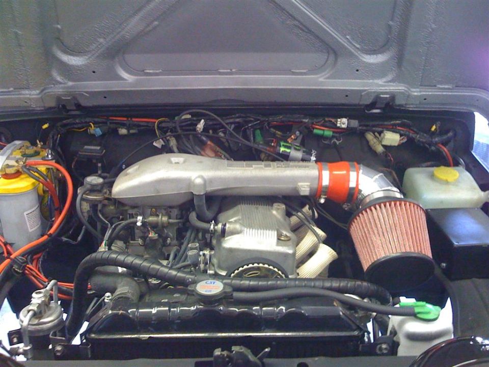 Fuel-injected Suzuki engine bay with alloy intake plenum and red cone air filter