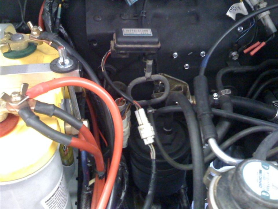 Engine bay wiring detail with red battery cable, relay box and vacuum lines