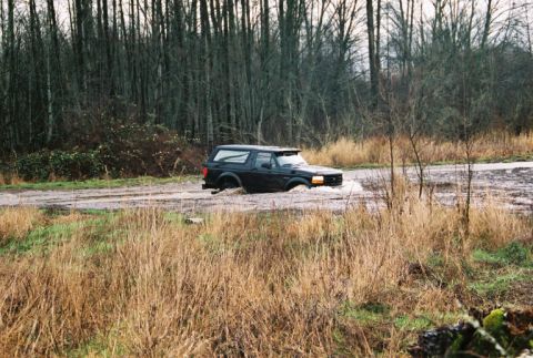 1995 Ford Bronco - 1995 Ford Bronco navigating through a muddy water crossing.
