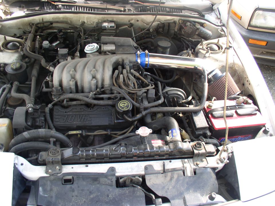 Engine bay with 3.0 V6, chrome intake tube and red battery