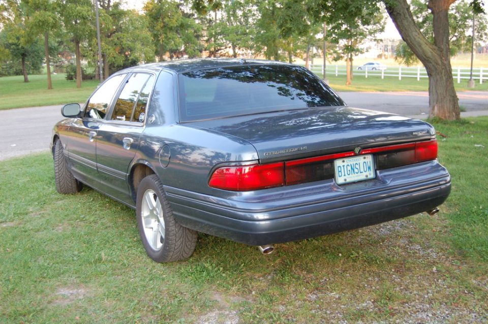 Rear passenger side view of a dark blue Mercury Grand Marquis with an Ontario license plate.