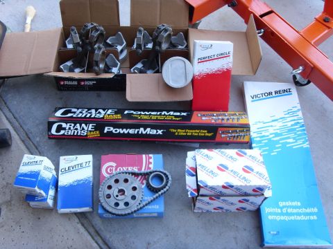 1989 Ford F-250 - A collection of engine parts including pistons, connecting rods, camshafts, a timing chain and gear set, and gasket sets are laid out on a…
