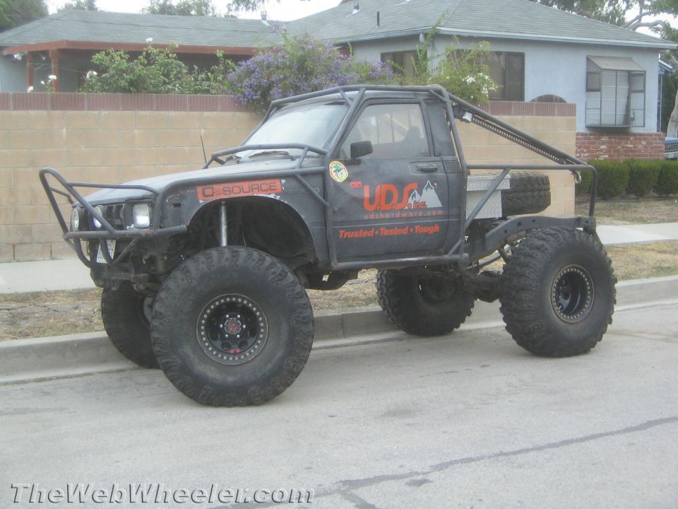 Black lifted Toyota pickup rock-crawler parked on a residential street