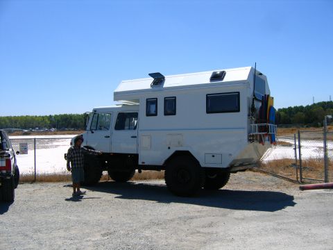 1991 Ford Bronco - Custom camper truck parked outdoors with a person standing beside it. Another vehicle is partially visible.