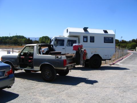 1991 Ford Bronco - This 1991 Ford Bronco is parked next to a large white camper truck.