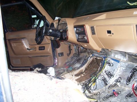 1991 Ford Bronco - The interior of a vehicle, likely a 1991 Ford Bronco, shows the dashboard, steering wheel, and door panel. The floor is partially disassemb…