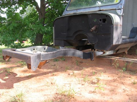1980 Jeep CJ7 - A Jeep body mid-restoration with the engine removed, showing the empty firewall and the bare front frame rails extending forward. The strip…