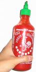 1985 Ford Bronco - A hand grips a bottle of Sriracha hot sauce against a white background.