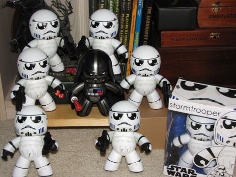 1991 Ford Bronco - A collection of Star Wars action figures, including stormtroopers and Darth Vader, are displayed on a shelf with books and boxes.