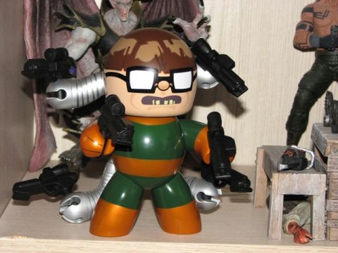 1991 Ford Bronco - A toy figure with multiple weapons is displayed on a shelf alongside other collectible figures and props.