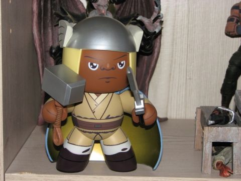 1991 Ford Bronco - A toy figure resembling a character with a hammer and sword is displayed on a shelf, with other figures and objects in the background.