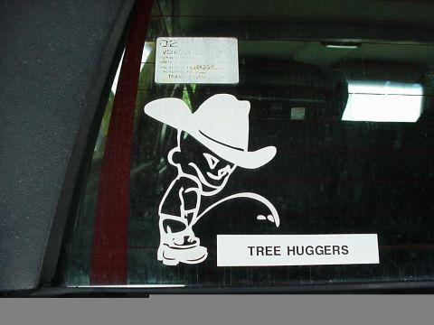 1995 Ford Bronco - A humorous sticker on a vehicle window depicts a cartoon character urinating on a "TREE HUGGERS" sign.