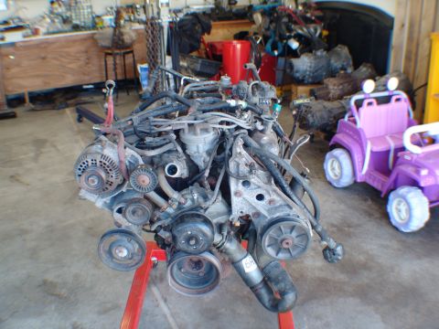 1996 Ford Bronco - Engine assembly on a stand, with a toy jeep in the background.