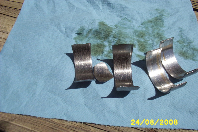 Engine bearings on a blue cloth with oil stains