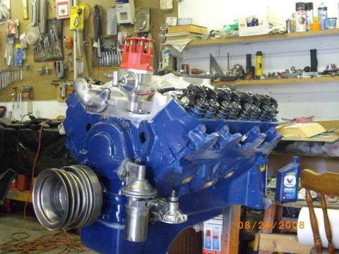 1964 Ford Galaxie - A freshly painted V8 engine block sits on a stand in a cluttered garage, ready for assembly.