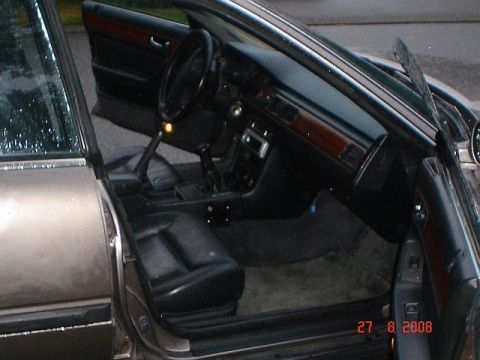 1990 Ford Bronco - The interior of a car is visible with the driver and passenger doors open, revealing the seats and dashboard.